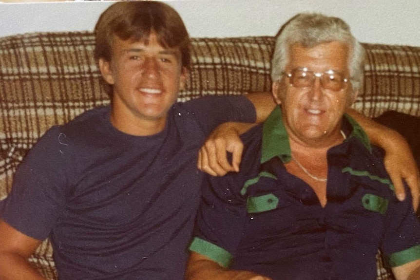 A father and son sit next to each other on a couch.