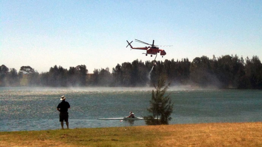 A water-bombing helicopter fills at the Sydney International Regatta Centre at Penrith.