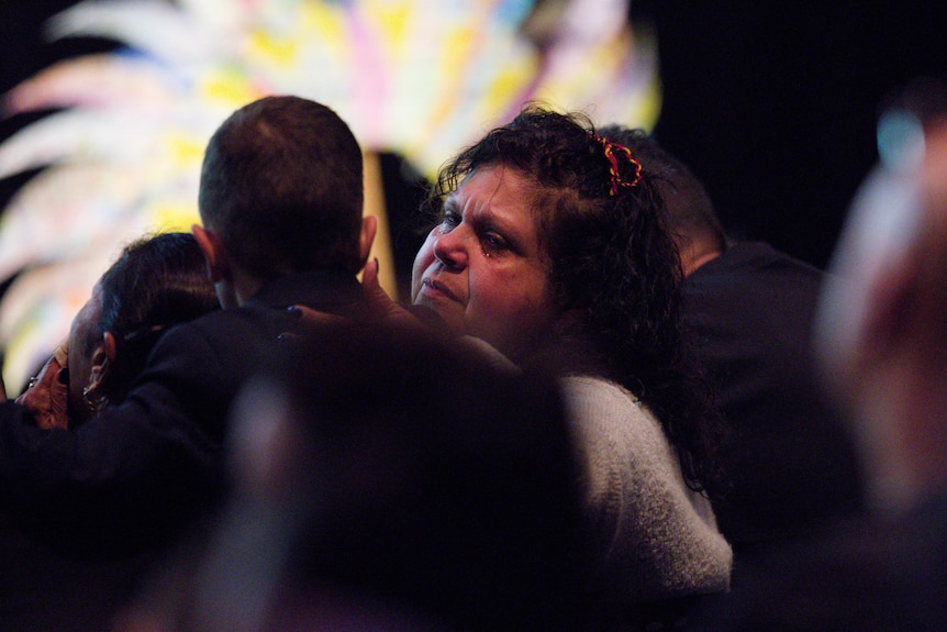 A woman visibly upset at a funeral