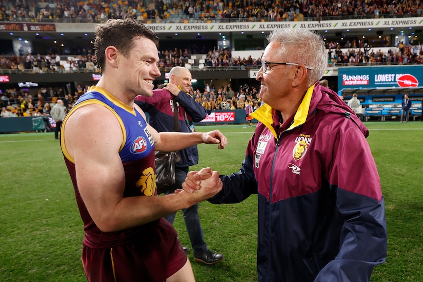 Brisbane Lions player Lachie Neale clasps hands with coach Chris Fagan after an AFL finals win over Richmond.