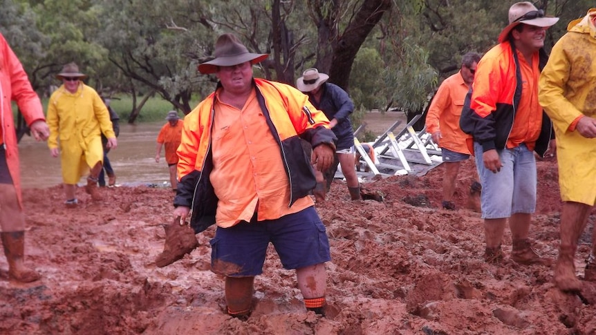 Locals and volunteers work to build a temporary levee in Charleville
