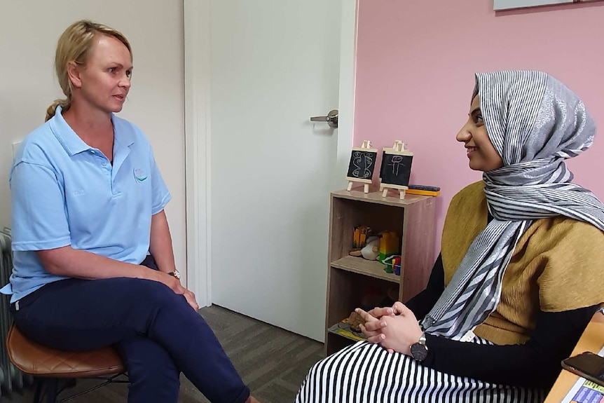 Shae Wilson sits in an appointment room, speaking with colleague Annie Haider.