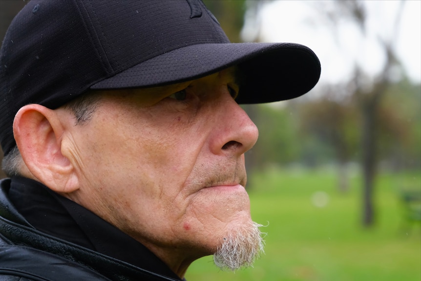 A profile shot of a man wearing a cap.