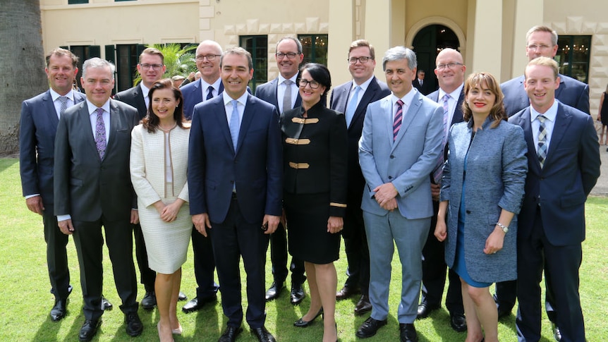 Steven Marshall and his new Cabinet smile for a group photo on the lawns of Government House.