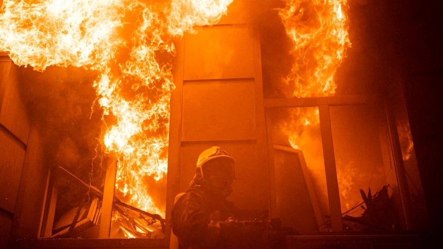 A firefighter works at a site of an administrative building heavily damaged by a Russian missile strike.