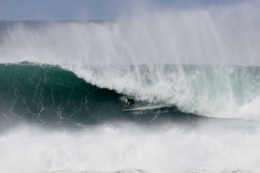 surfing getting under the lip of a large wave