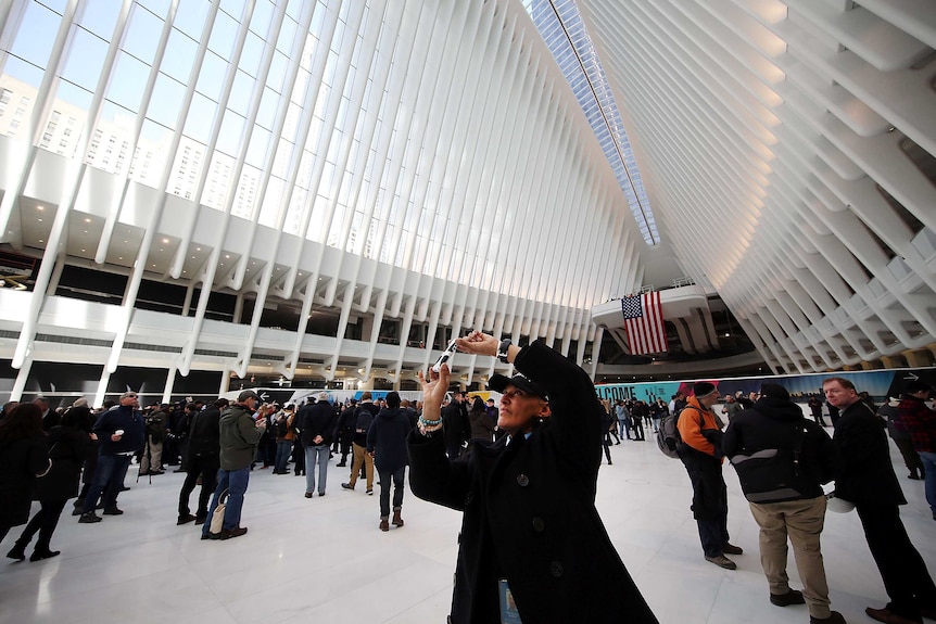 People walk through the new partially opened World Trade Center Transportation Hub