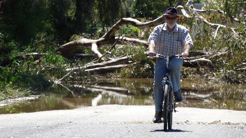 Man on a bike in front of a flooded park