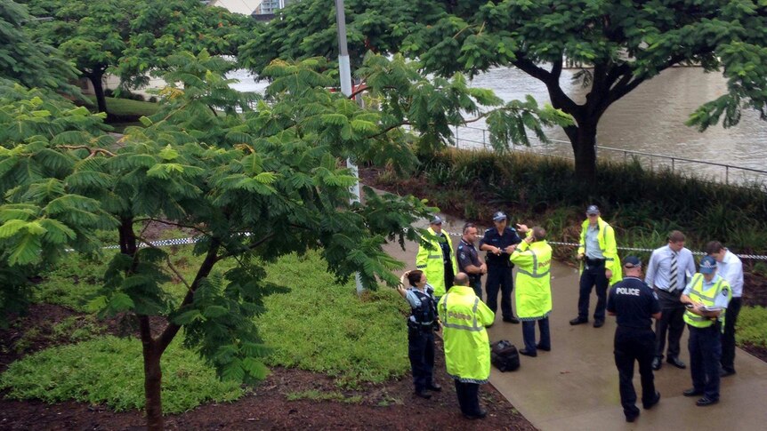 Police gather at the scene where a woman's body was found near the Kurilpa Bridge at South Brisbane.