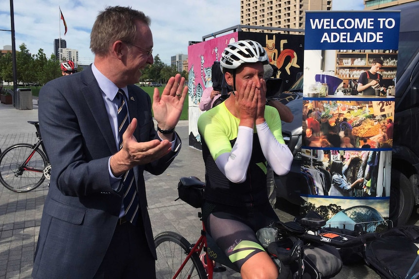 Martin Haese claps as cyclist Kristof Allegaert takes a breather.