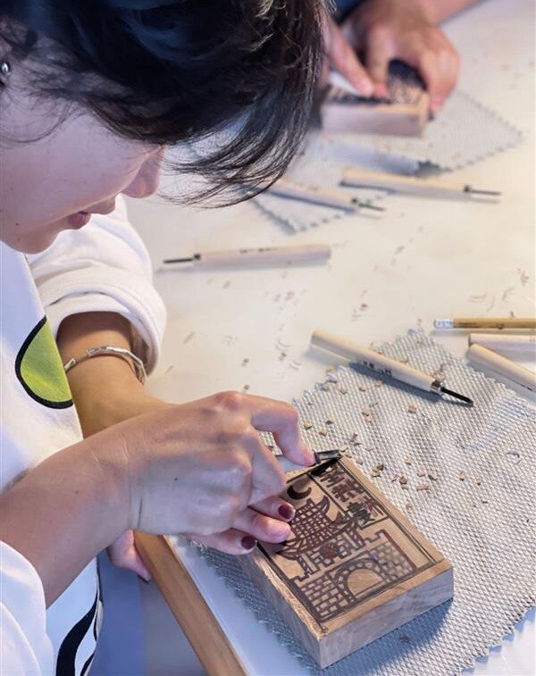 A girl making wood carvings.