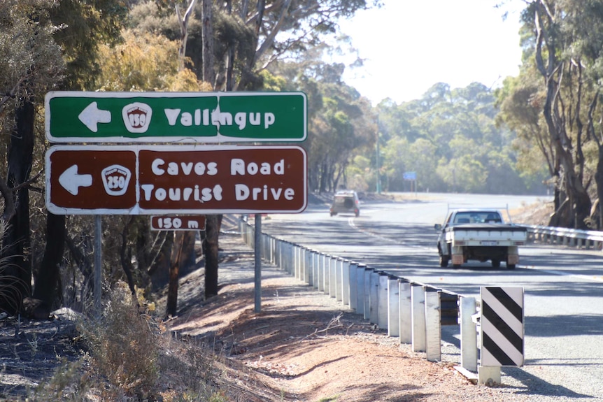 The white text on a road sign pointing to Yallingup has melted from the heat of the bushfire.