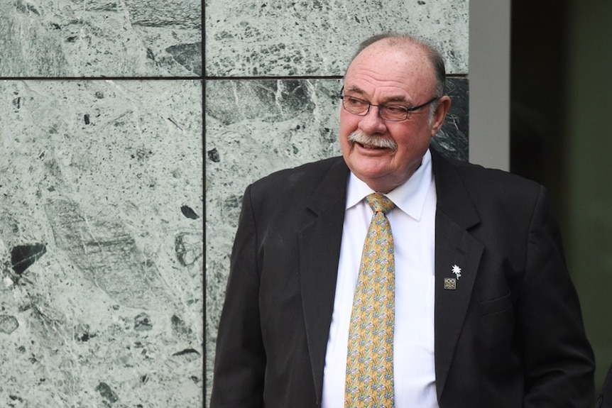 Warren Entsch smiles as he leans against a wall in Parliament.