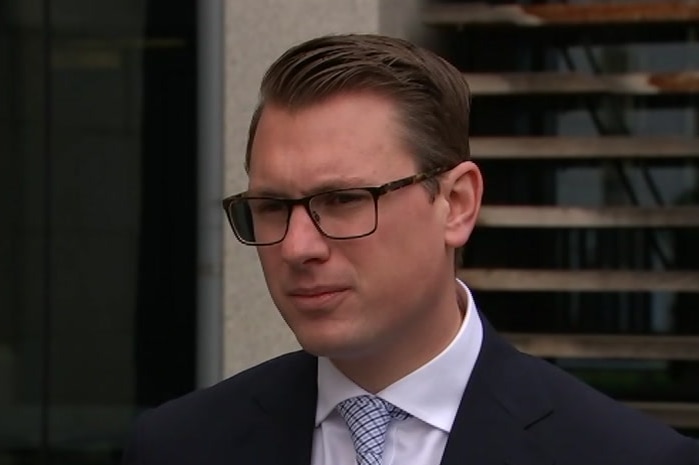 A man with glasses wearing a suit and tie