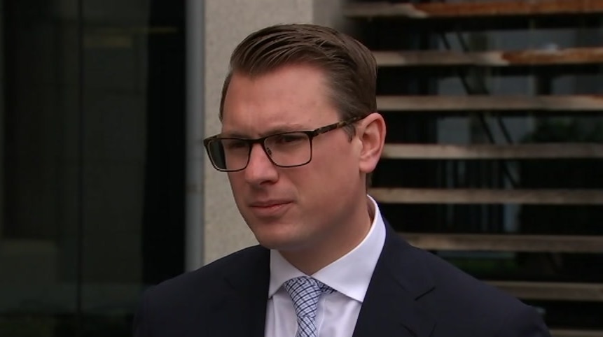 A man with glasses wearing a suit and tie