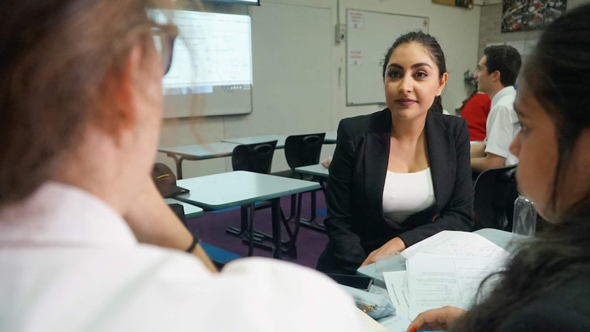 A woman speaks to students.