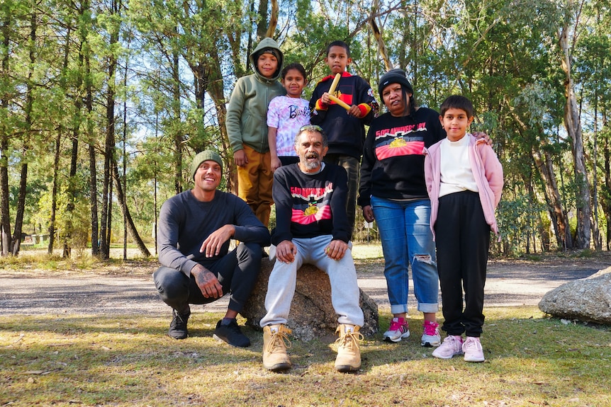 Marley (left) poses with a group of Indigenous children at a bush camp in Gameroi country.