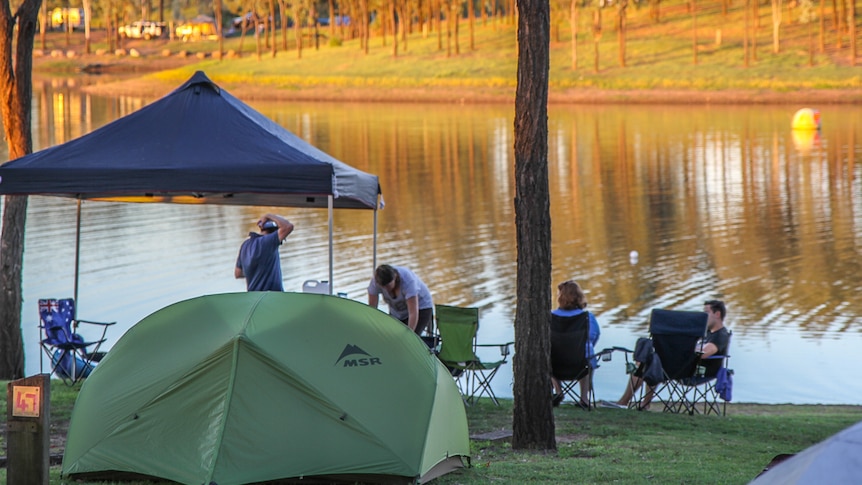 Campers sitting near a dam.