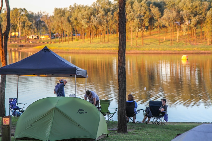 Campers sitting near a dam.