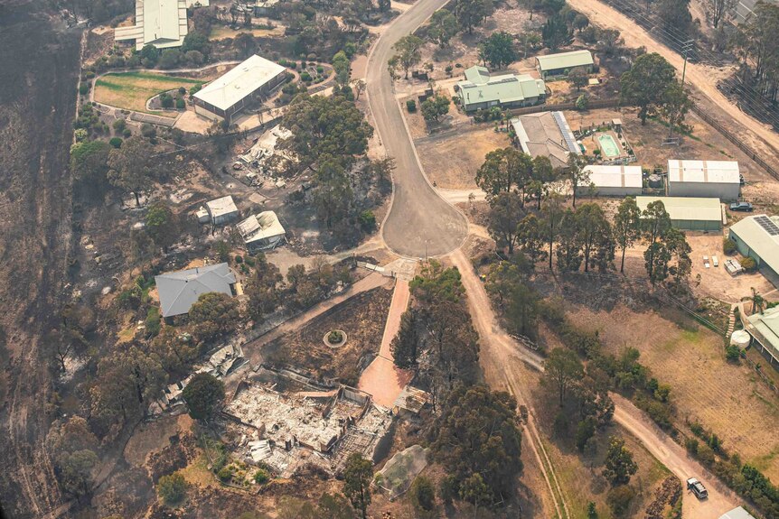 An aerial view showing a cul-de-sac where two properties are destroyed by fire.