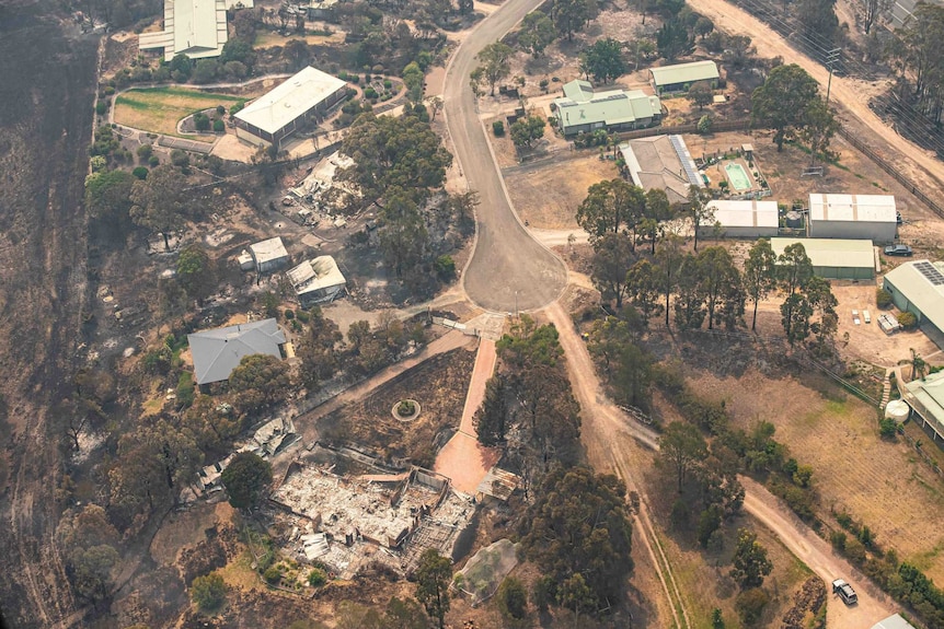 An aerial view showing a cul-de-sac where two properties are destroyed by fire.