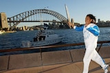 Cathy Freeman runs with the Olympic torch in front of the Sydney Opera House