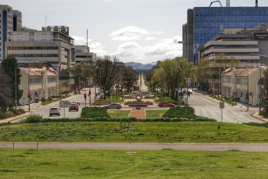 A main street lined with trees and greenery.