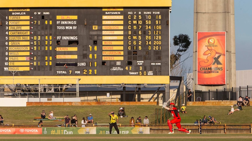 A wide shot from ground level of SA batsman Adam Zampa hitting a ball at the WACA Ground with the scoreboard in the background.