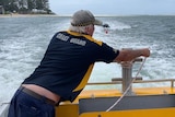 A coast guard man towing a jetski