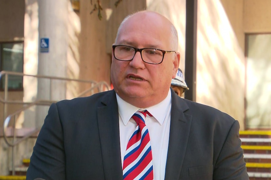 A man wearing a stripey tie and glasses