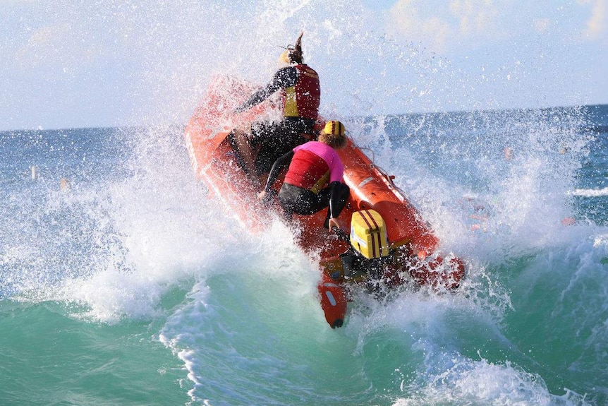Two men on a life boat riding a wave
