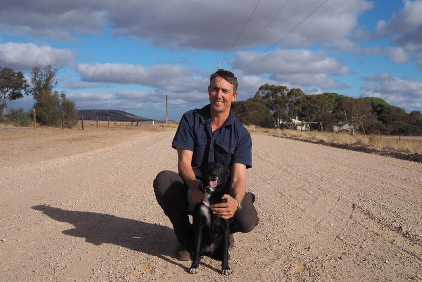 Farmer Tom Michael on a country road with his dog.
