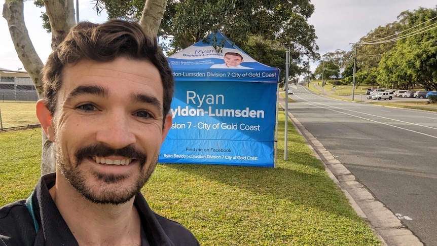 A man with a moustache in front of a party tent.