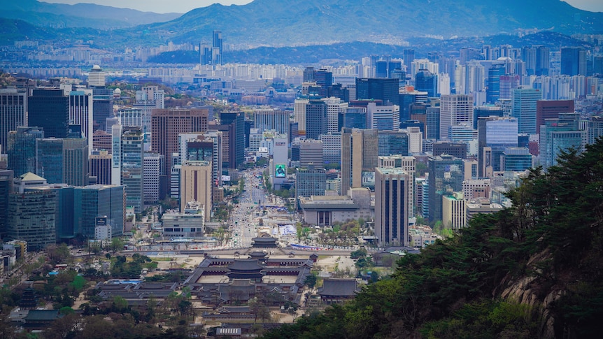 A view of the Seoul skyline with mountains in the background 