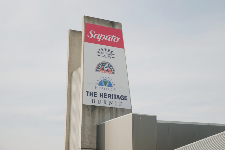 Large Saputo sign emblazoned with cheese brands sits against empty sky