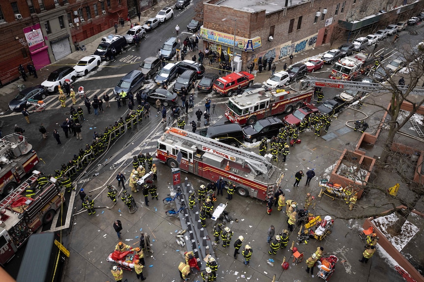 Pompierii lucrează în afara unui bloc de apartamente după un incendiu în Bronx