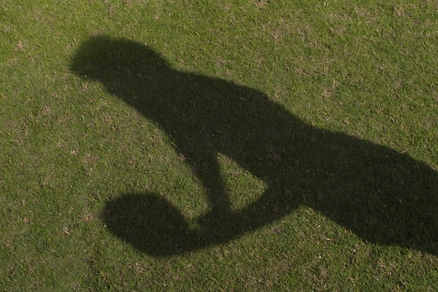 shadow of West Coast Eagles player Sophie McDonald handballing a football