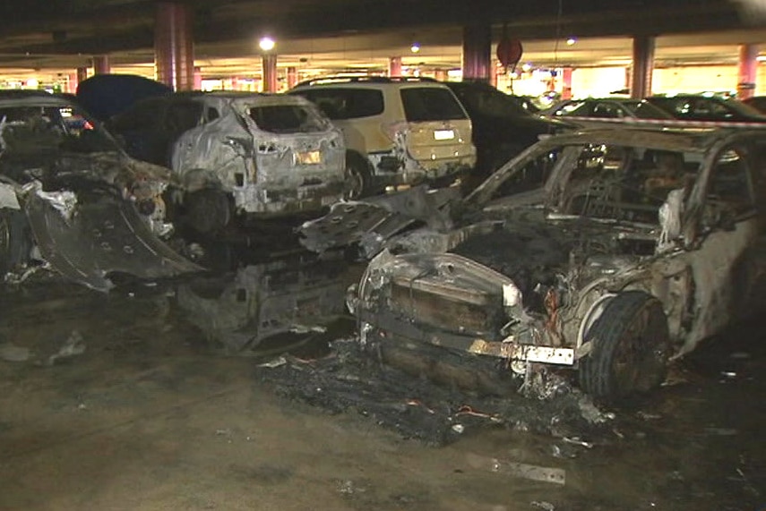 Cars showing signs of fire damage.