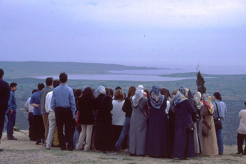 A group of Turkish men and women look out over a landscape