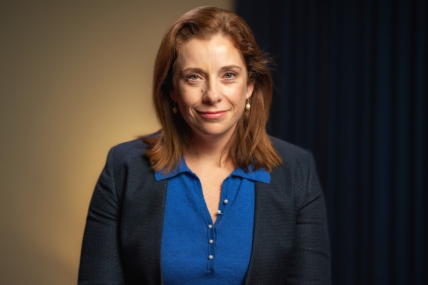 Woman wearing a blue blouse with a jacket. 