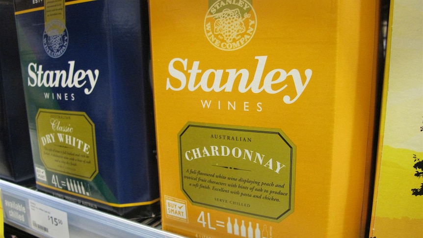 A blue and yellow box on a shelf.  They both have the name of an alcohol company written on them.