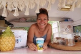 Rachael Willson smiles as she leans on the counter inside her Ruby Caravan.