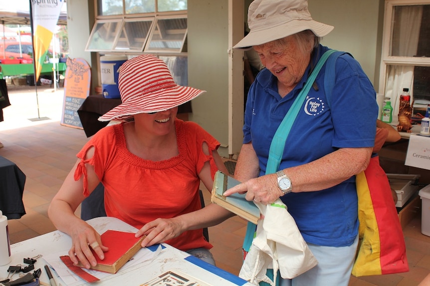 Kate Burbeck and Rosalie Breen examine a book