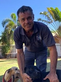 Peter Trembath stands with dogs in a backyard in Katherine.