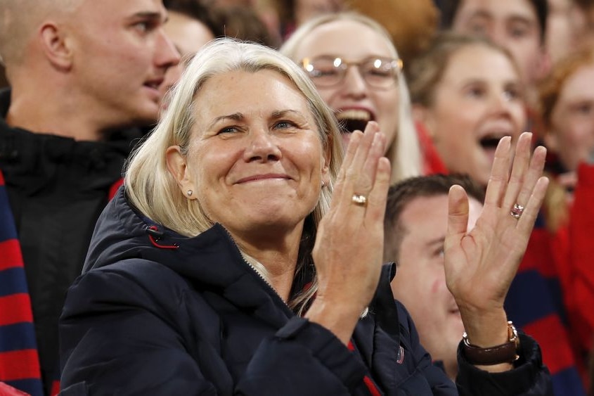 A photo of Kate Roffey smiling in the crowd, about to clap.