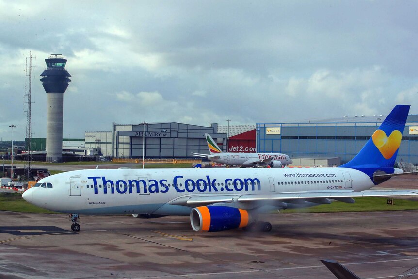 A plane with the words Thomas Cook written on the side in a dark blue font.