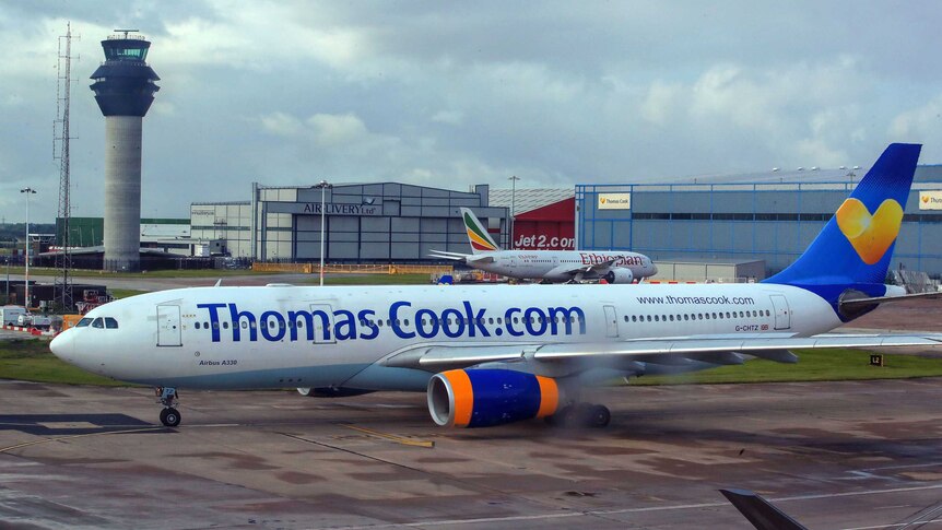 A plane with the words Thomas Cook written on the side in a dark blue font.