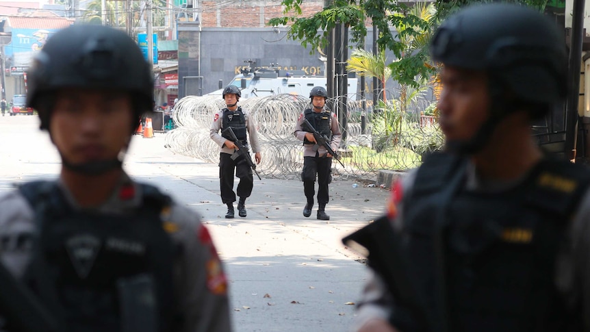 Armed officers outside the HQ of elite Indonesian police force, Mobile Brigade, following a riot inside the West Javan compound.