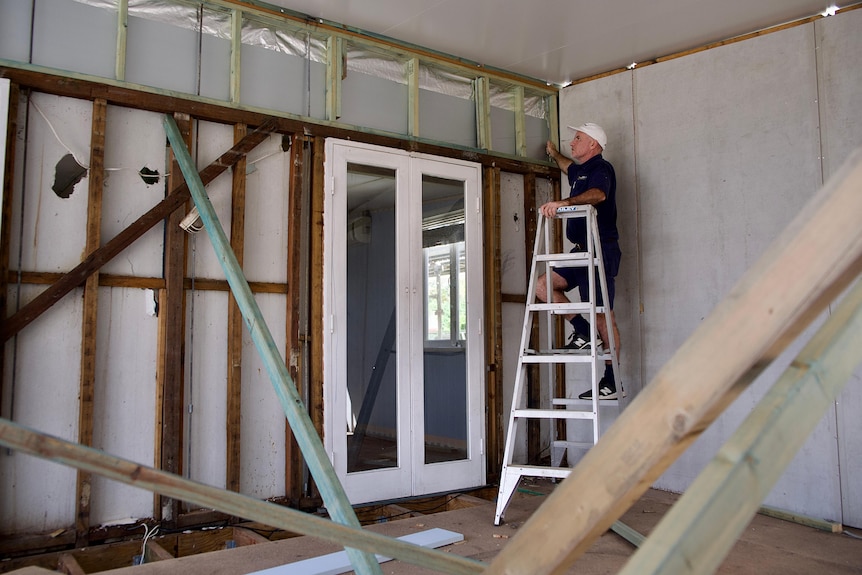 un hombre en una escalera en un sitio de construcción