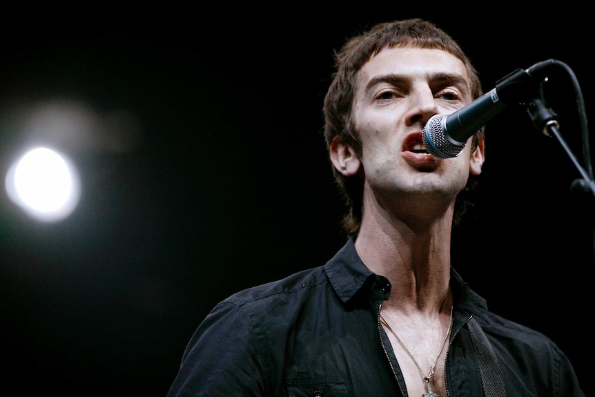 Richard Ashcroft sings into a microphone